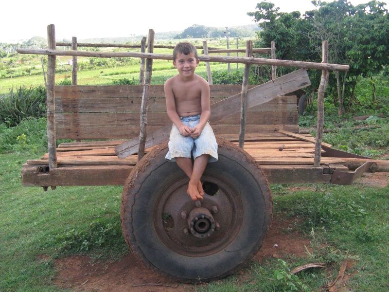 Viñales boy sitting cart wheel tire
